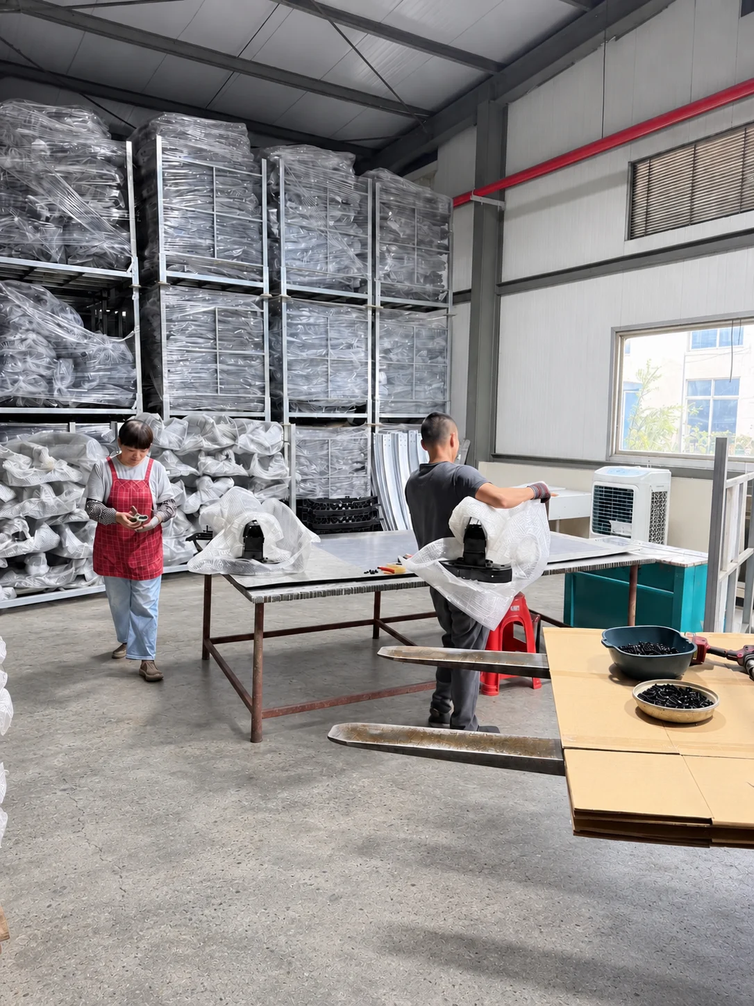 Worker at a workstation beside racks of components